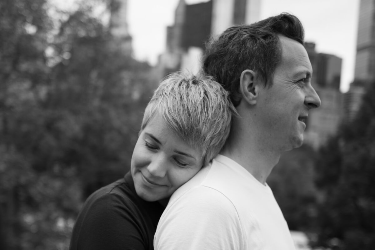 She rests her head on his back with her eyes closed, Central Park engagement photos