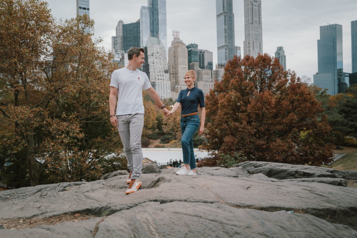 Couple walking hand in hand in Central Park in autumn